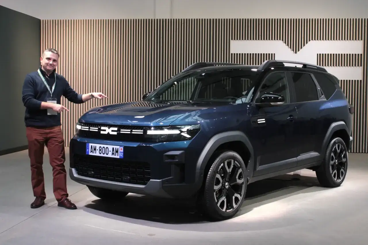 Mężczyzna prezentuje nowy, ciemnoniebieski Dacia Bigster z silnikiem LPG.