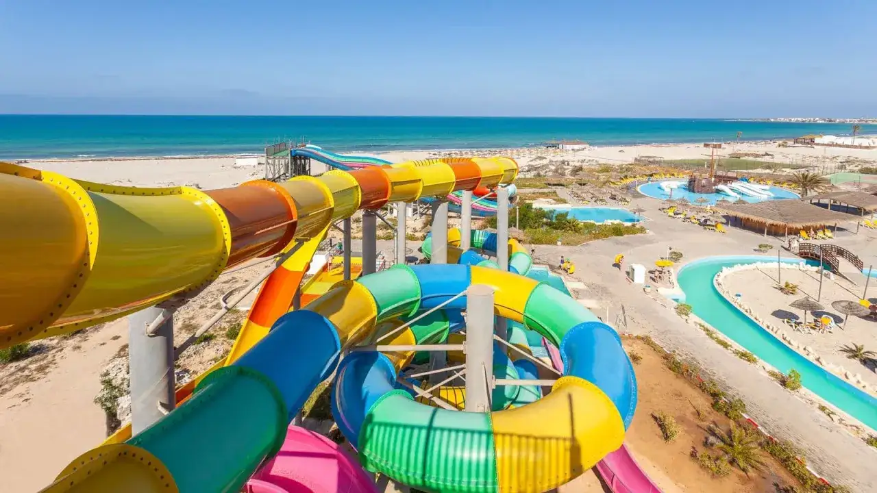 Kolorowe zjeżdżalnie wodne w Djerba Aqua Resort, z widokiem na morze. Idealne miejsce na wakacje, zgodnie z licznymi djerba aqua resort opinie.