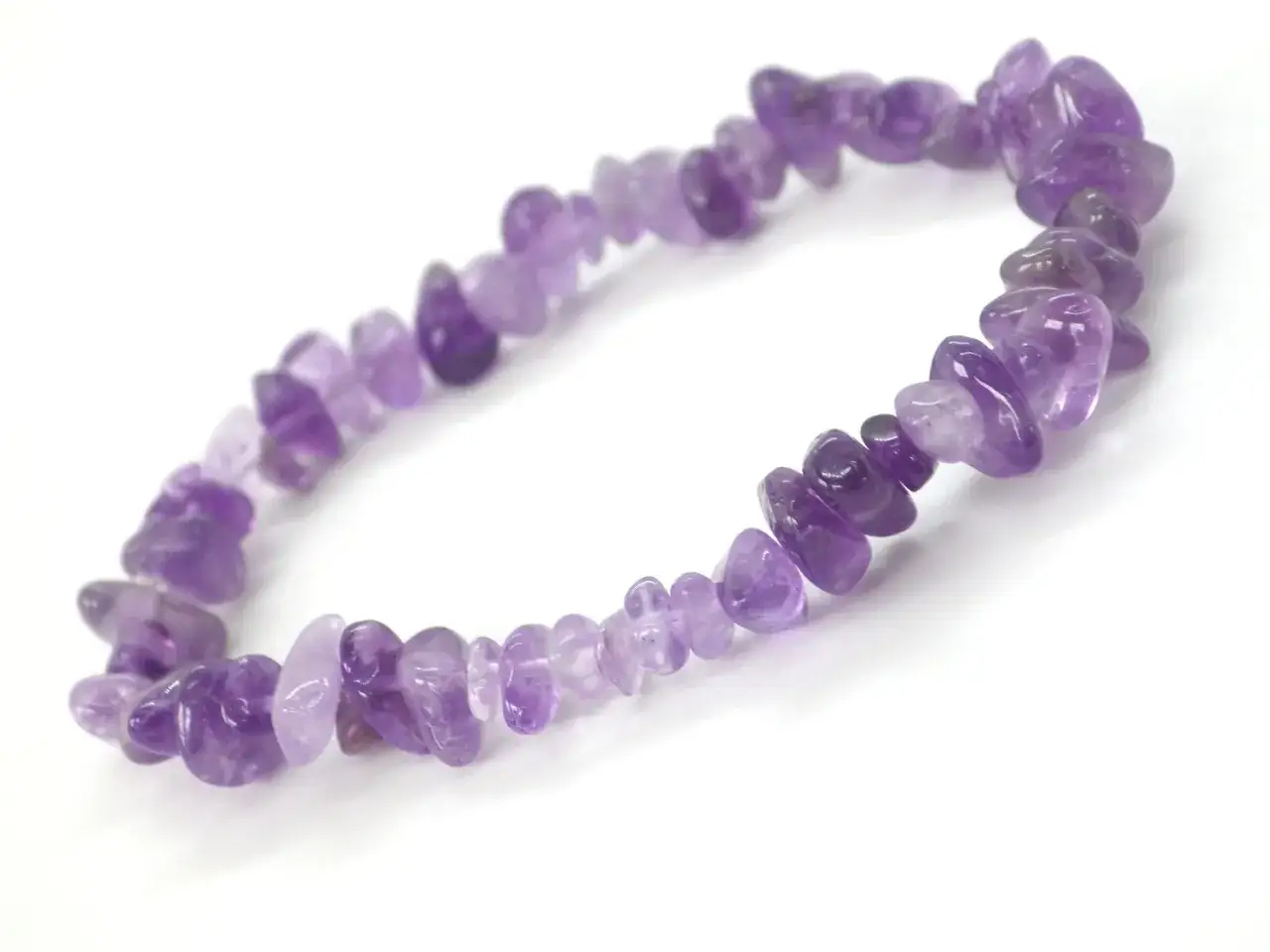 Pulsera de amatista, conocida por sus propiedades calmantes y de equilibrio. Las piedras irregulares brillan con tonos violetas.