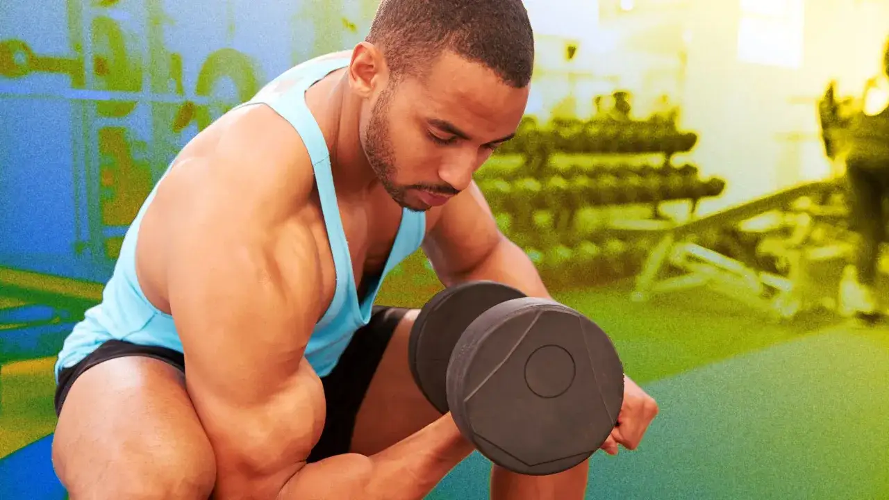 Mężczyzna ćwiczy biceps z hantlem, szukając najlepszych ćwiczeń na biceps.