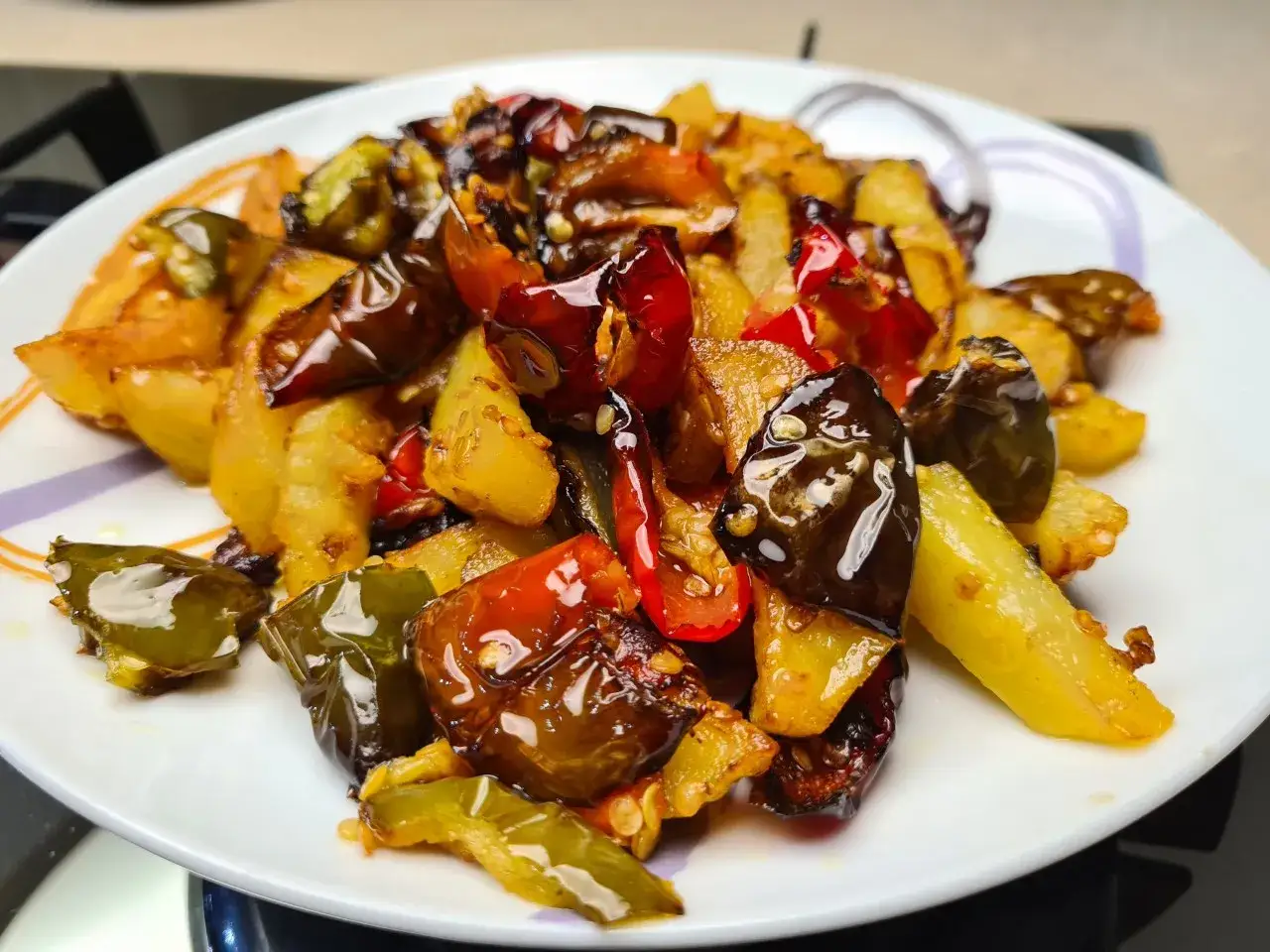Pipi e patate saltate in padella, un contorno saporito e colorato, con peperoni verdi e rossi che si mescolano alle patate dorate.