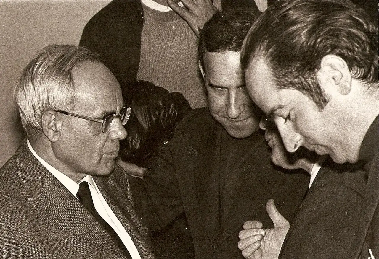 Karl Rahner im Gespräch mit zwei Männern. Sie wirken vertieft in eine Diskussion.