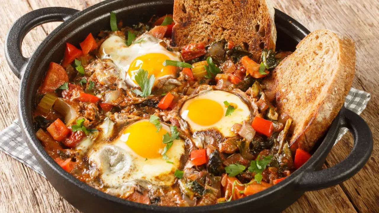 Uova in padella con verdure e pane tostato. Un piatto saporito, quasi un'acqua cotta rivisitata, perfetto per un brunch.
