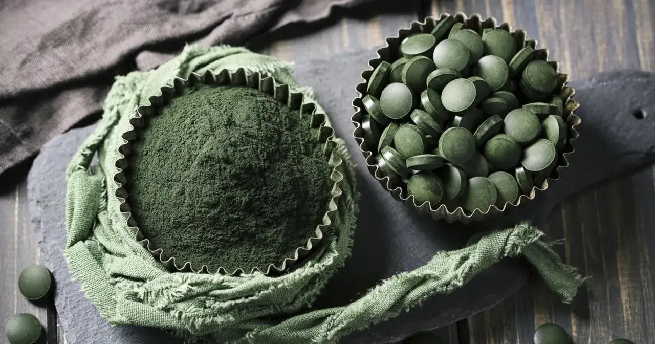 Zielony proszek i tabletki z chlorelli. Choć suplementacja jest popularna, warto znać potencjalne chlorella skutki uboczne.