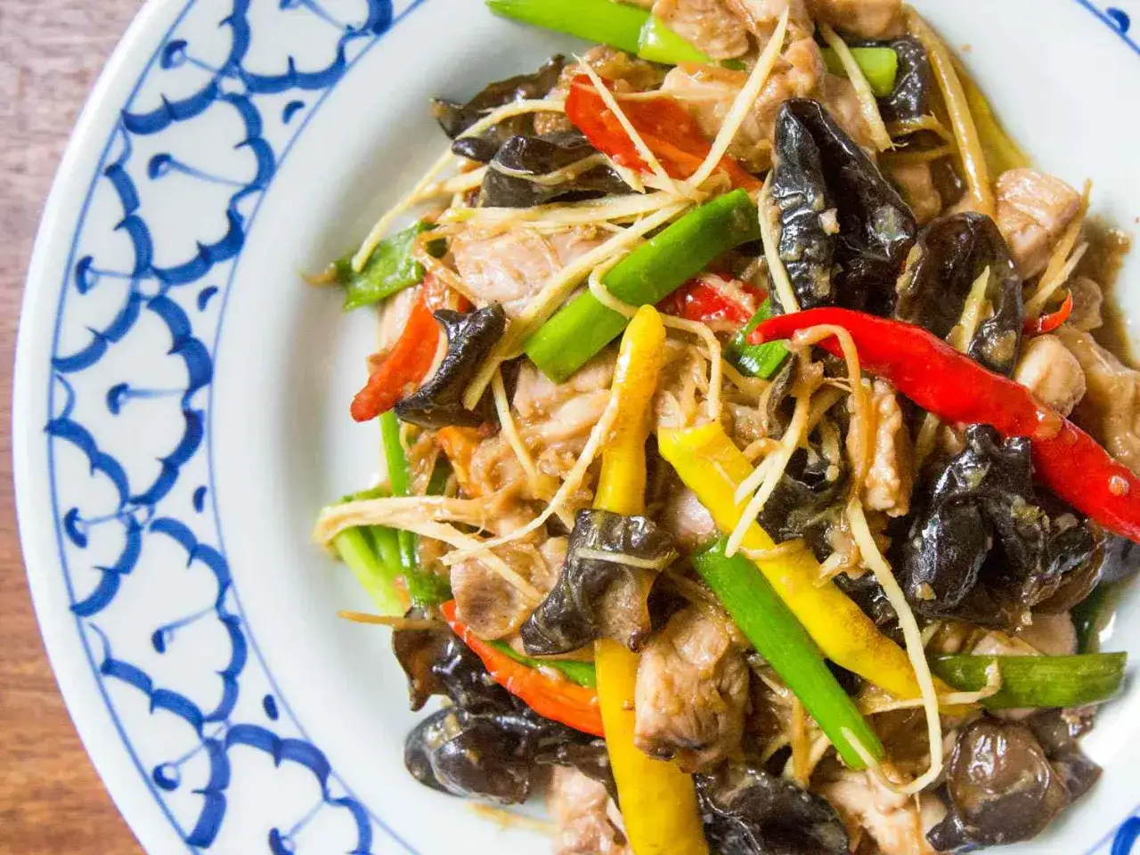 En tallrik med pad khing, en thailändsk rätt med kyckling, ingefära, svamp och chili.