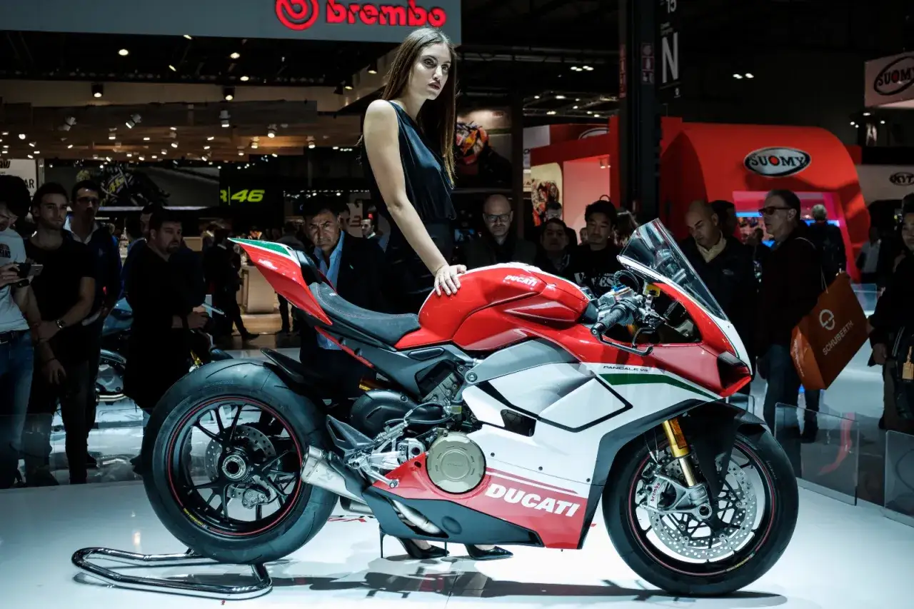 Modella con una Ducati rossa e bianca, un'icona della fiera moto Milano.