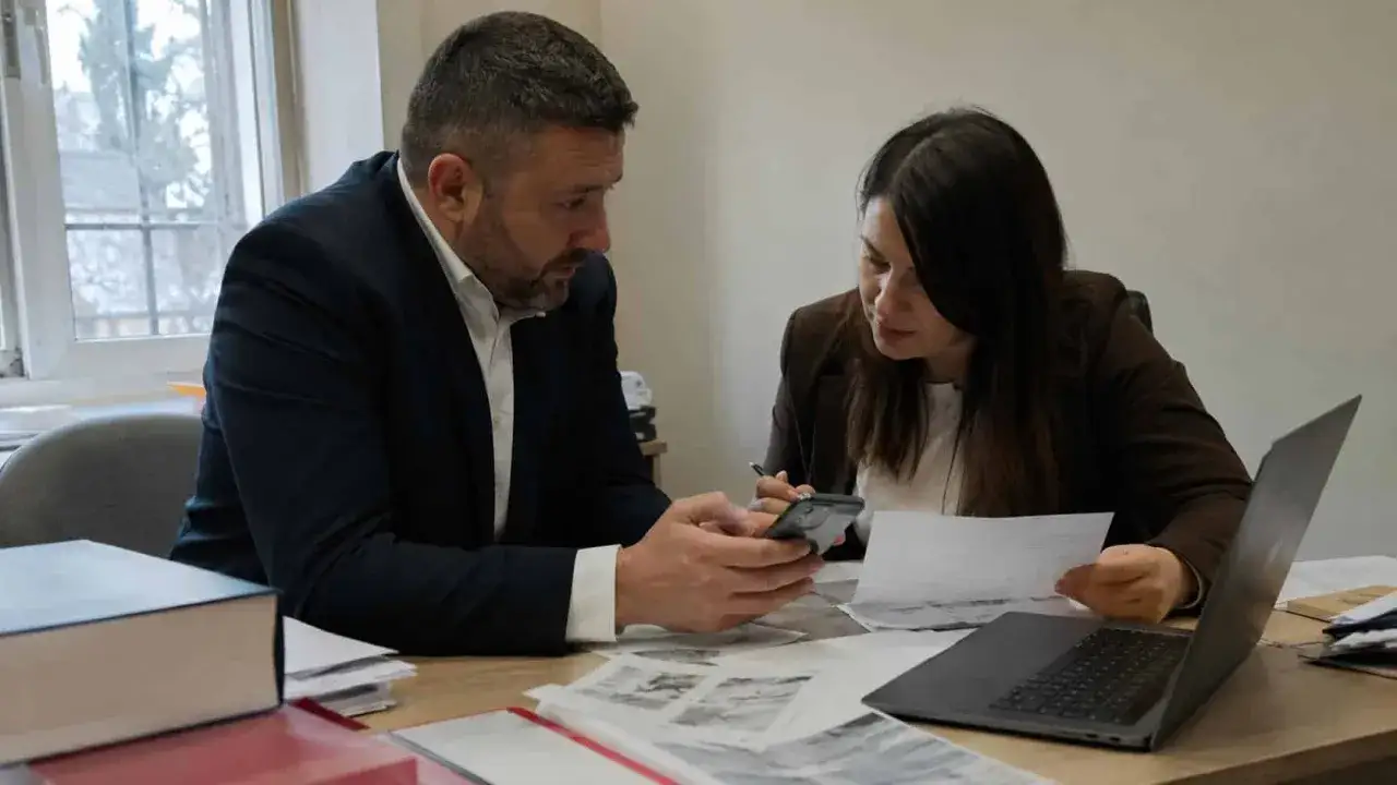 Mężczyzna pokazuje kobiecie coś na telefonie, analizują dokumenty. Czy to dowód na zniesławienie?