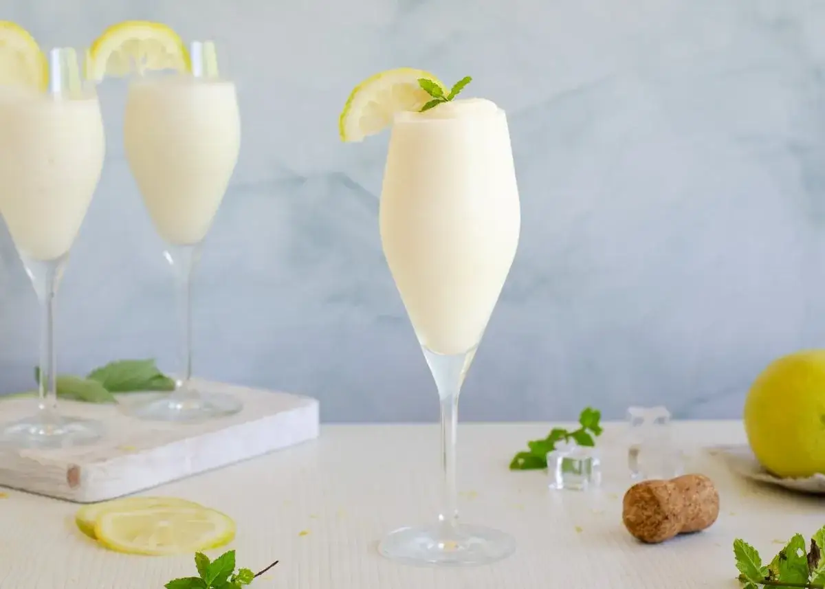 Refrescante sorbete de limón en copas elegantes, decorado con rodajas de limón y hojas de menta. Perfecto para un día caluroso.