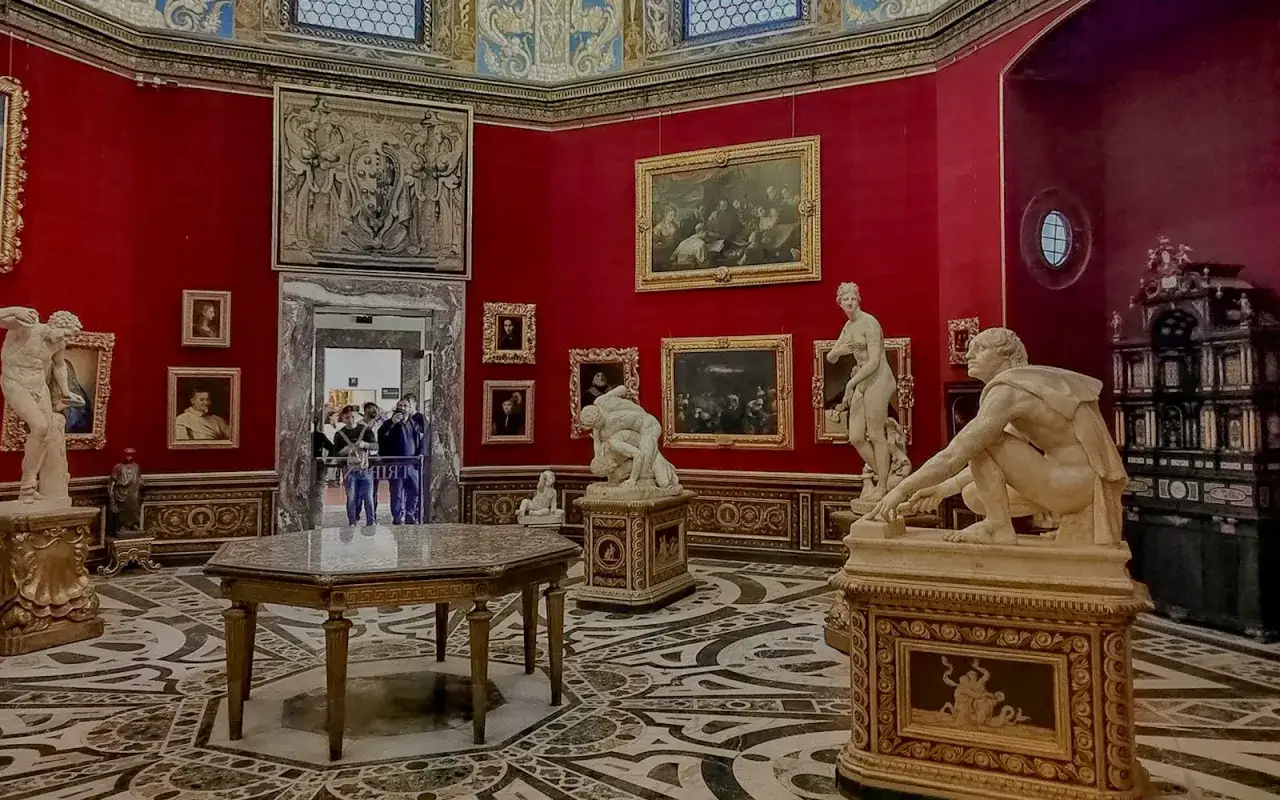 Un weekend a Firenze tra sculture classiche e dipinti rinascimentali in una sala dai toni rossi vibranti.