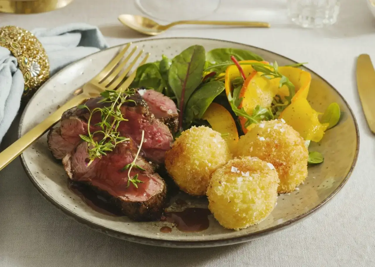 Skivat oxfil&eacute; med en mustig s&aring;s, serverad med krispiga potatisbollar och en fr&auml;sch sallad. En perfekt s&aring;s till oxfil&eacute; f&ouml;r en festlig m&aring;ltid.