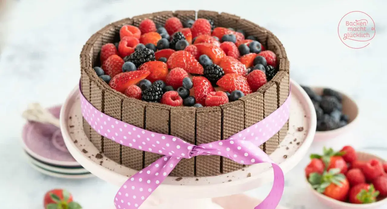 Eine k&ouml;stliche Kinderschokolade Torte, umrandet von Waffelr&ouml;llchen und &uuml;ppig belegt mit frischen Beeren und Erdbeeren.