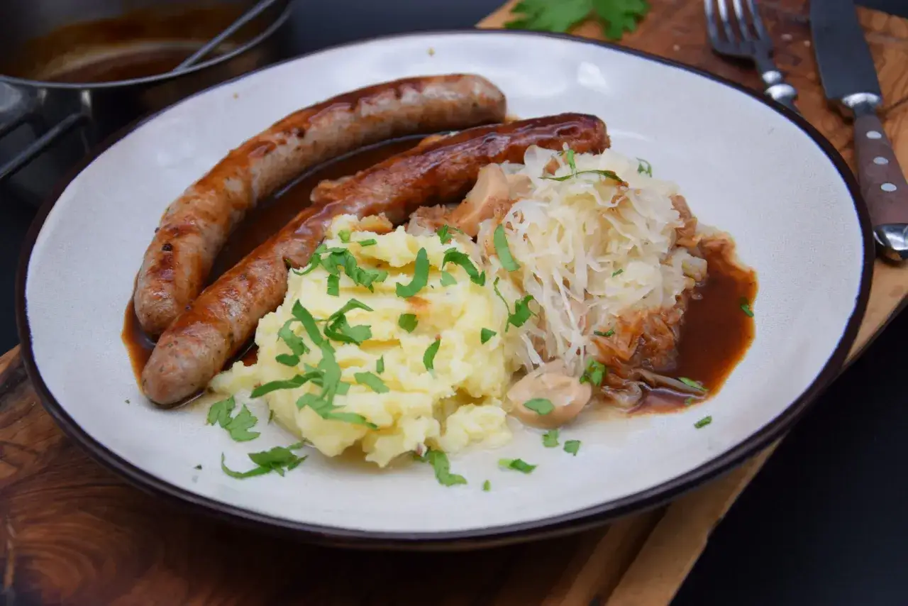 Herzhaftes Gericht mit zwei Bratwürsten, Kartoffelbrei und Sauerkraut. Ein Klassiker, der immer schmeckt.