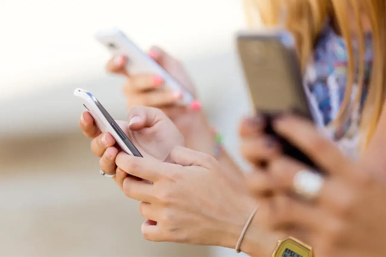 Dłonie trzymające smartfony, przygotowujące się do wyłączenia 3G plus.