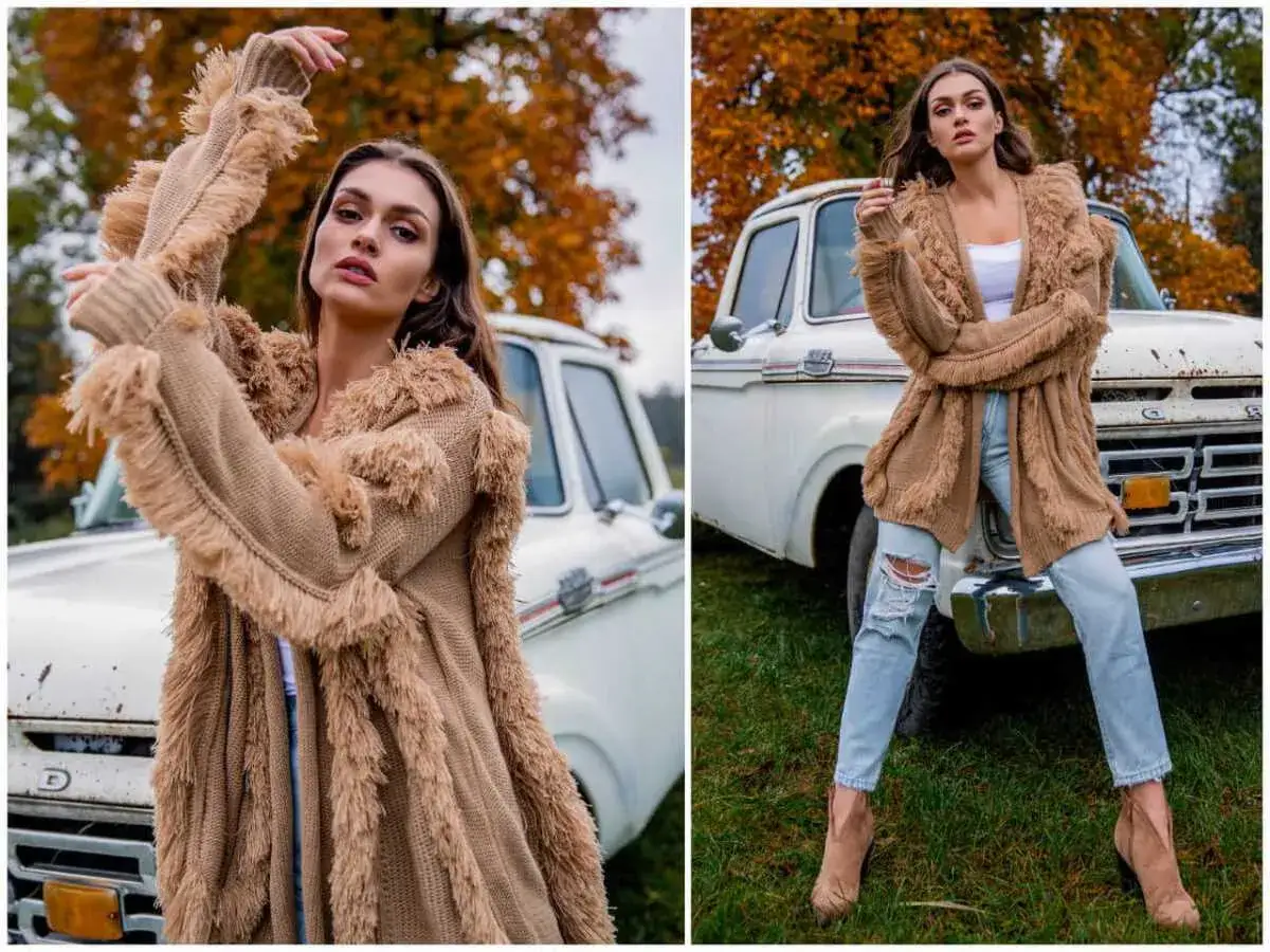 Modne swetry z frędzlami w stylu boho, idealne na jesień. Modelka w brązowym kardiganie i jeansach.