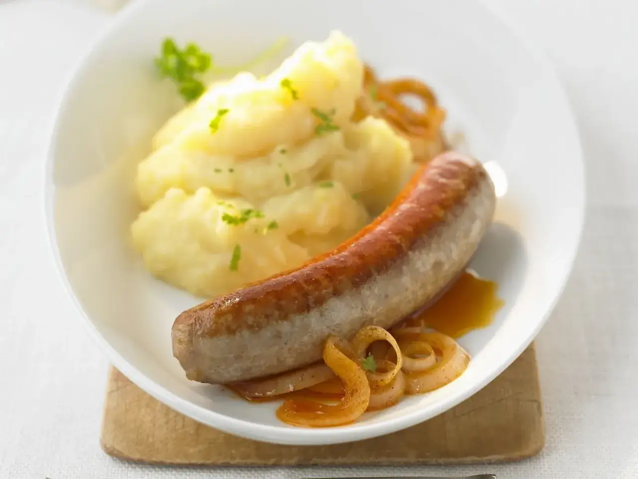 Herzhafte Bratwurst mit Kartoffelp&uuml;ree und karamellisierten Zwiebeln. Ein Klassiker, der zu vielen Bratwurst Rezepten passt.