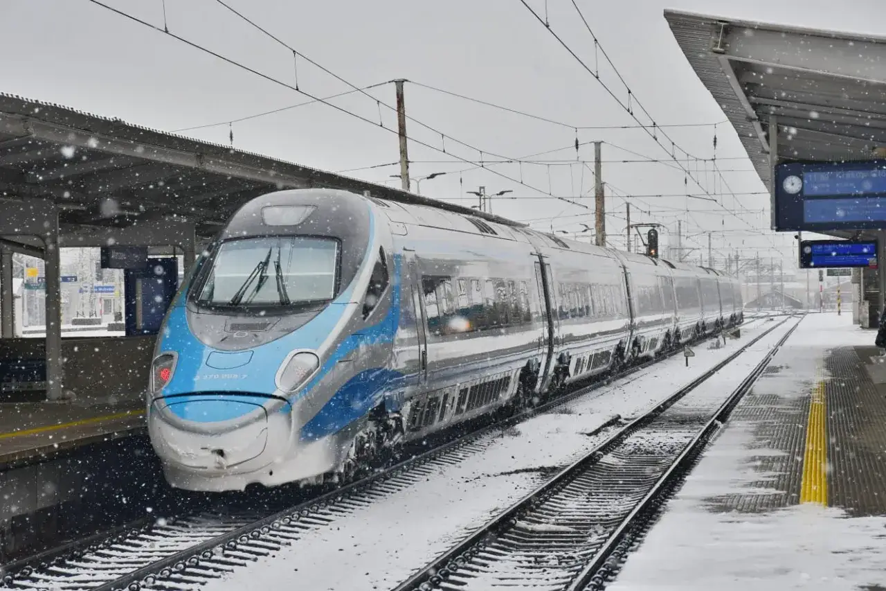 Nowoczesny pociąg Pendolino na śnieżnym peronie, gotowy do podróży z Kielc do Warszawy.