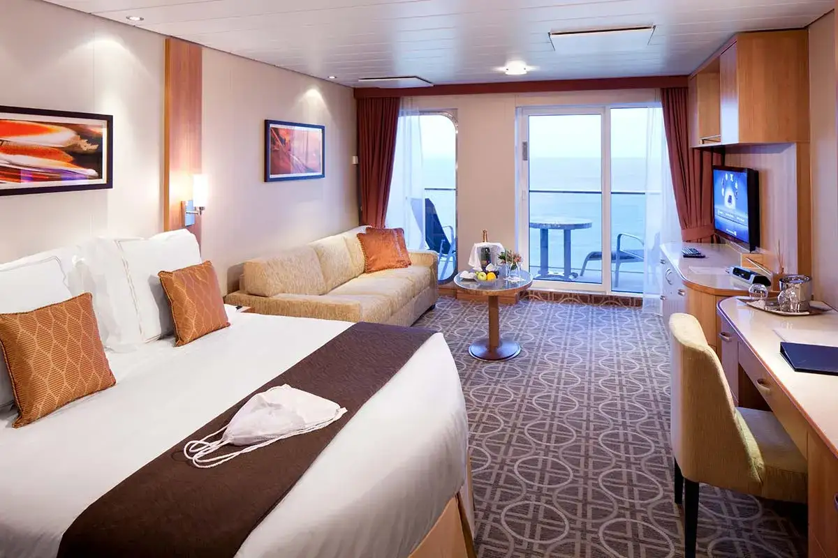 Interno cabina nave da crociera con letto, divano, balcone e vista mare. Le dimensioni cabine navi da crociera variano, questa &egrave; spaziosa.