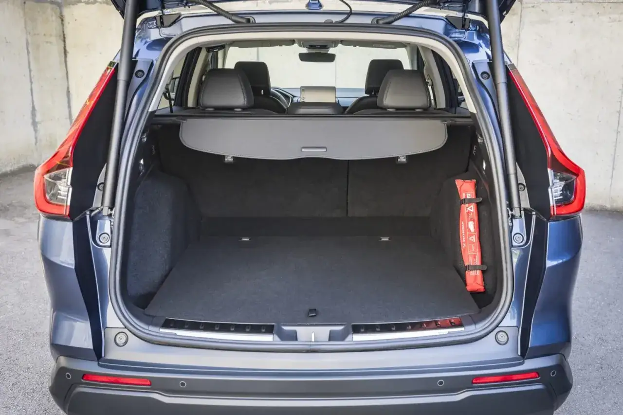 Bagażnik Hondy CR-V Hybrid gotowy na podróż. Widoczna apteczka i roleta bagażnika.