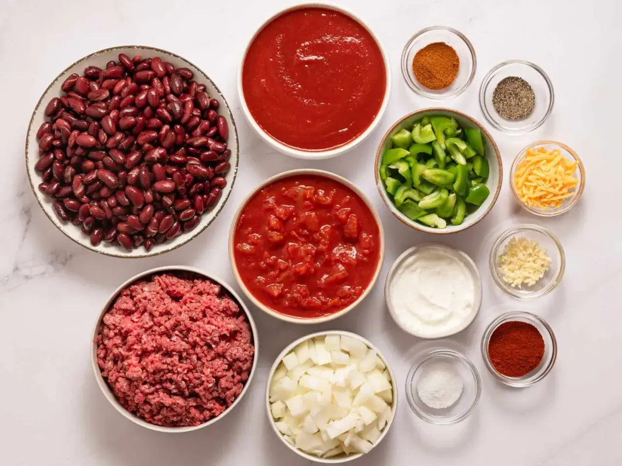 Zutaten f&uuml;r Chili: Kidneybohnen, Hackfleisch, Tomaten, Zwiebeln, Paprika, Knoblauch, K&auml;se, Gew&uuml;rze. Wenn das Chili zu scharf, was tun? Saure Sahne hilft!