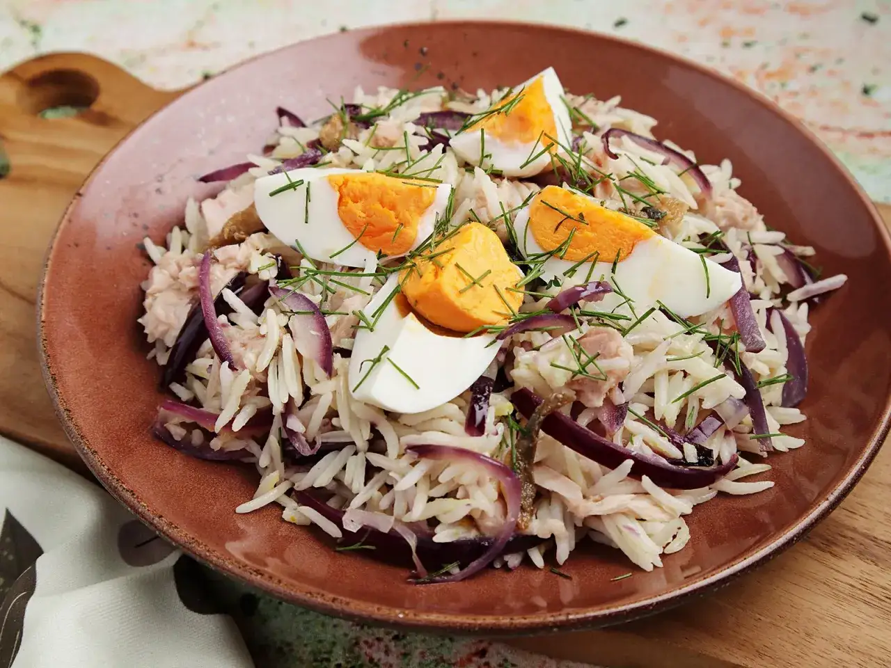 Reissalat mit Thunfisch, garniert mit gekochten Eiern und Dill. Ein leichter und leckerer Salat für jede Gelegenheit.
