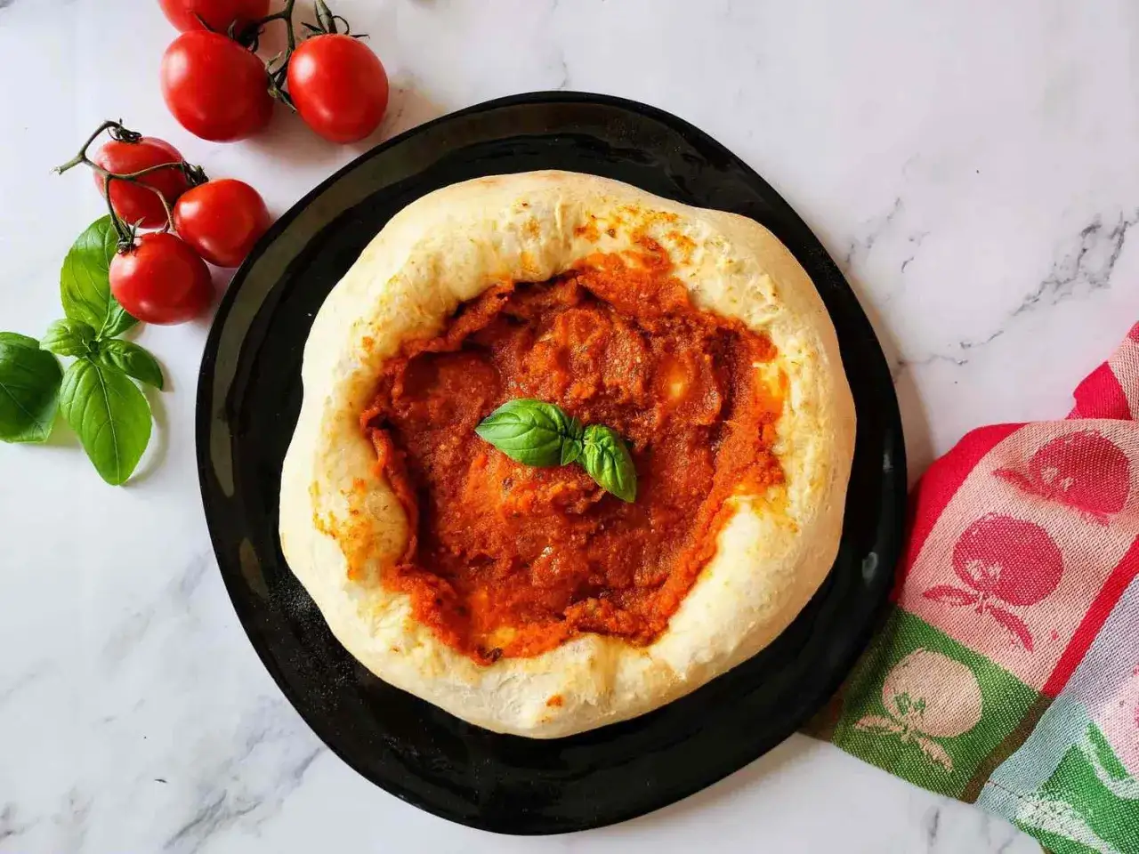 Frisch gebackener Teig mit einer köstlichen, selbstgemachten pizza sauce wie in der pizzeria. Frische Tomaten und Basilikum daneben.