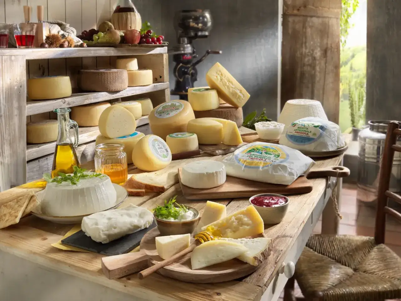 Varietà di formaggi freschi e stagionati, tra cui ricotta, caciotta toscana e formaggi a pasta dura, disposti su un tavolo di legno rustico.