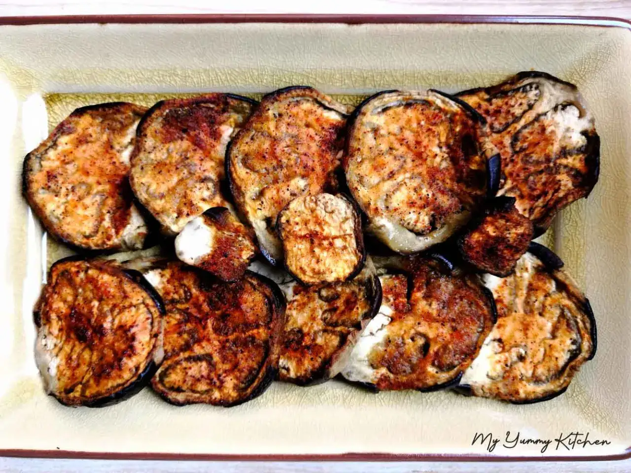 Tranches d'aubergine au four, dor&eacute;es et l&eacute;g&egrave;rement caram&eacute;lis&eacute;es, dispos&eacute;es dans un plat. Un d&eacute;lice simple et savoureux.