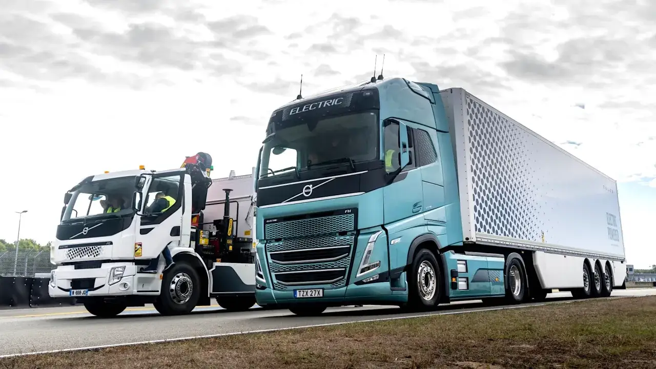 Deux camions Volvo électriques, un blanc avec grue et un bleu turquoise avec remorque, illustrent la consommation poids lourd 44t.
