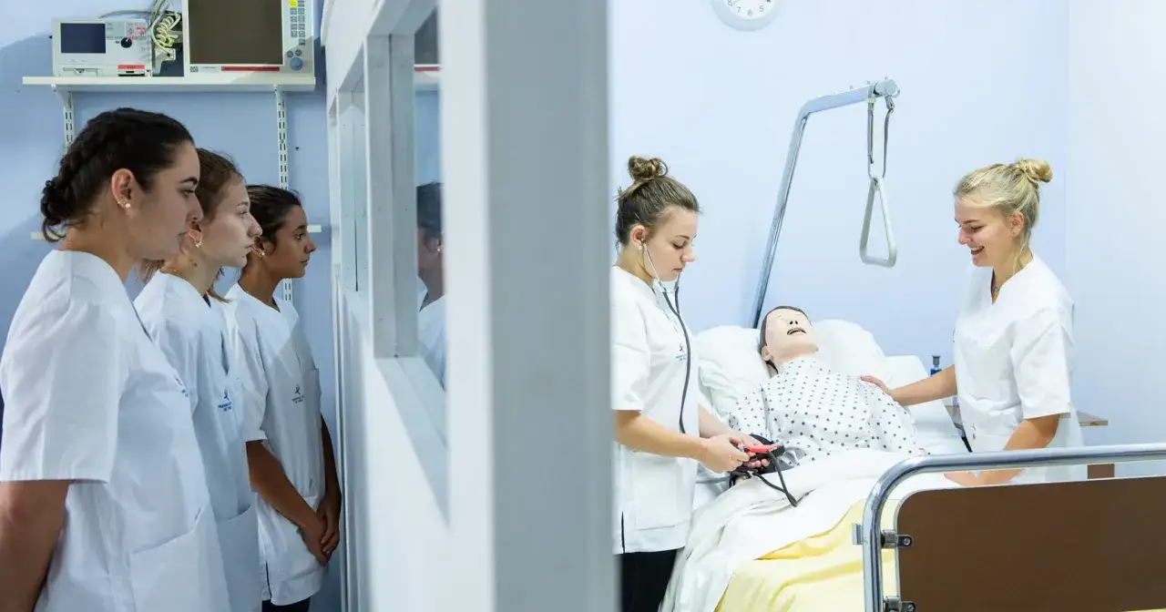 Des étudiantes en formation à l'école d'infirmière de Bruxelles pratiquent sur un mannequin.