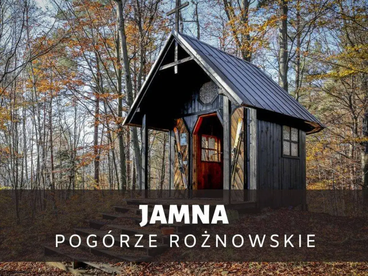Drewniana kapliczka w lesie, jesienne liście, narty przy wejściu. Jamna, Pogórze Rożnowskie.