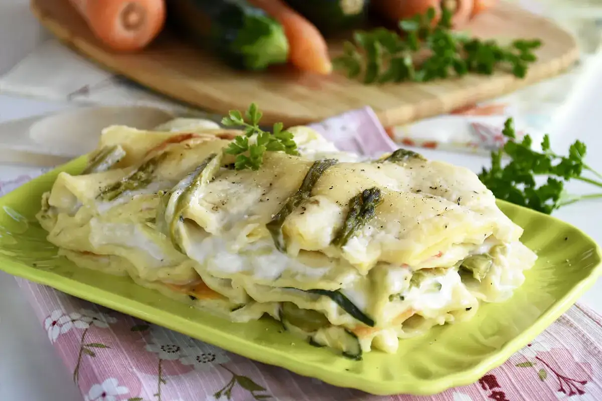Lasagne primavera cremose con verdure fresche, un piatto invitante che celebra i sapori della stagione.