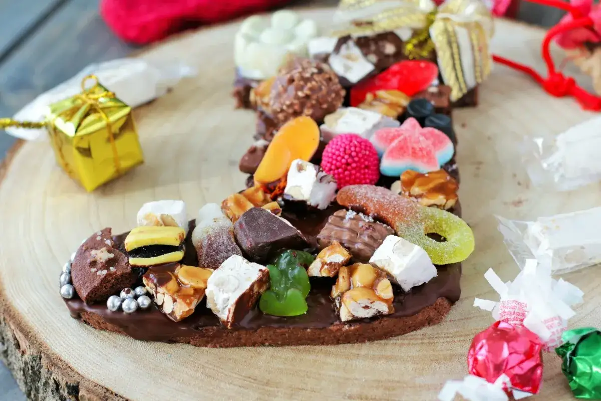 Una calza della Befana piena di dolciumi, come in una filastrocca sulla Befana, con caramelle gommose, torrone e cioccolatini.