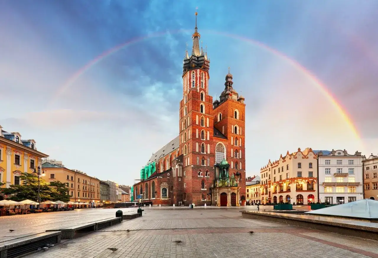 Tęcza nad Rynkiem Gł&oacute;wnym, gdzie kr&oacute;luje Bazylika Mariacka, jeden z najcenniejszych zabytk&oacute;w Krakowa.