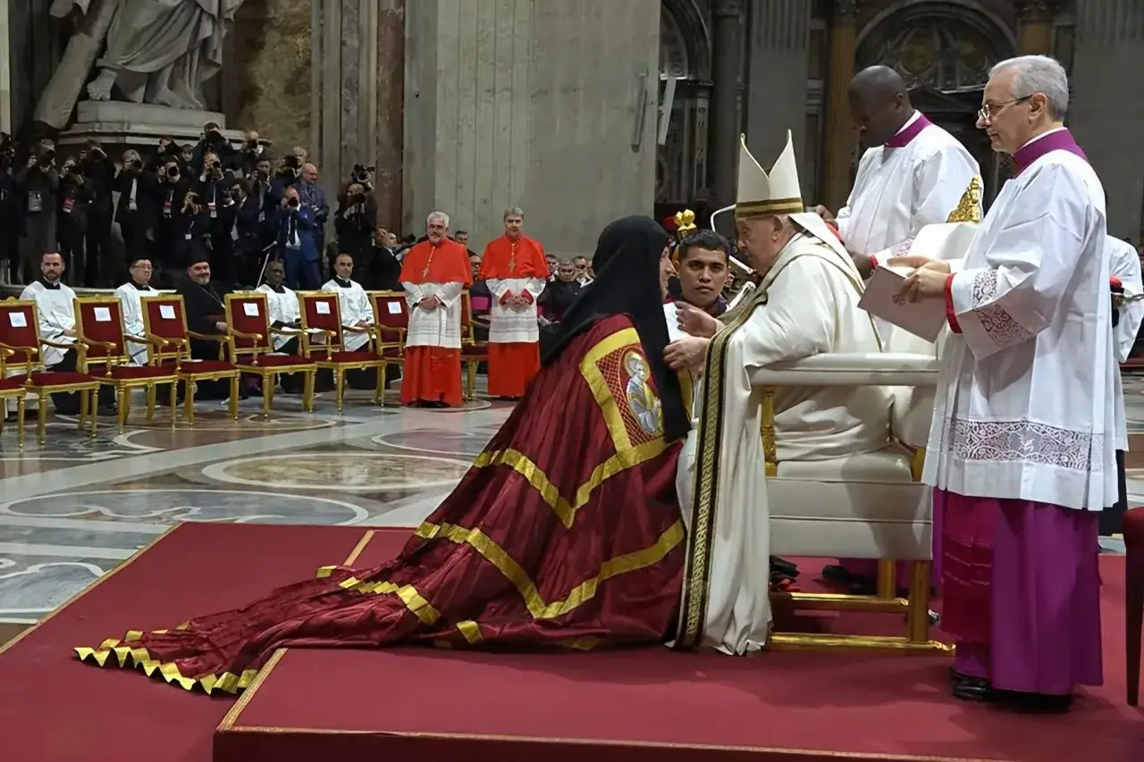 Papież Franciszek błogosławi najmłodszego kardynała w bogato zdobionej szacie.