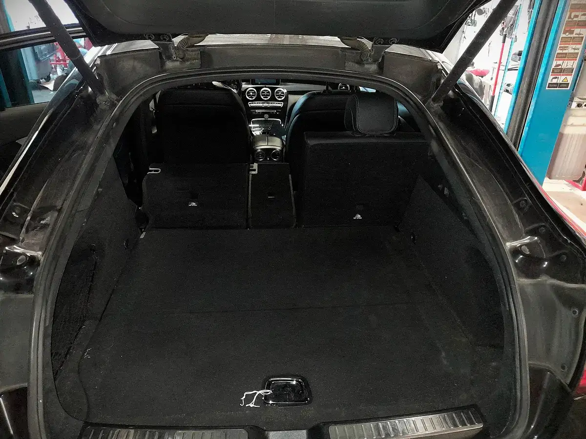 Pusta przestronna przestrzeń bagażowa Mercedesa GLC, idealna do przewożenia bagażu. Wymiary wnętrza sugerują komfortowe podróżowanie.