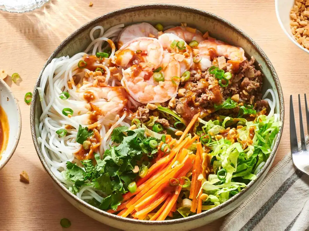 Bunter Sommerrollen Salat mit Reisnudeln, Garnelen, Hackfleisch, knackigem Gemüse und Erdnussdressing.