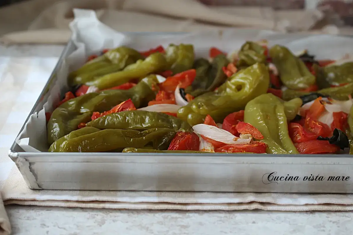 Friggitelli al forno con pomodori e cipolla, pronti per essere gustati.