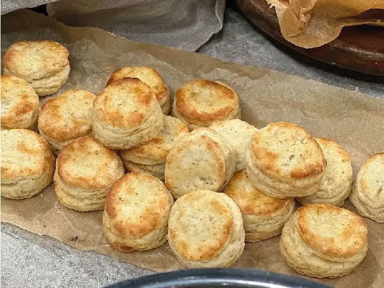En hög med gyllene, små scones som ser nybakta ut. Perfekta för en mysig fika.