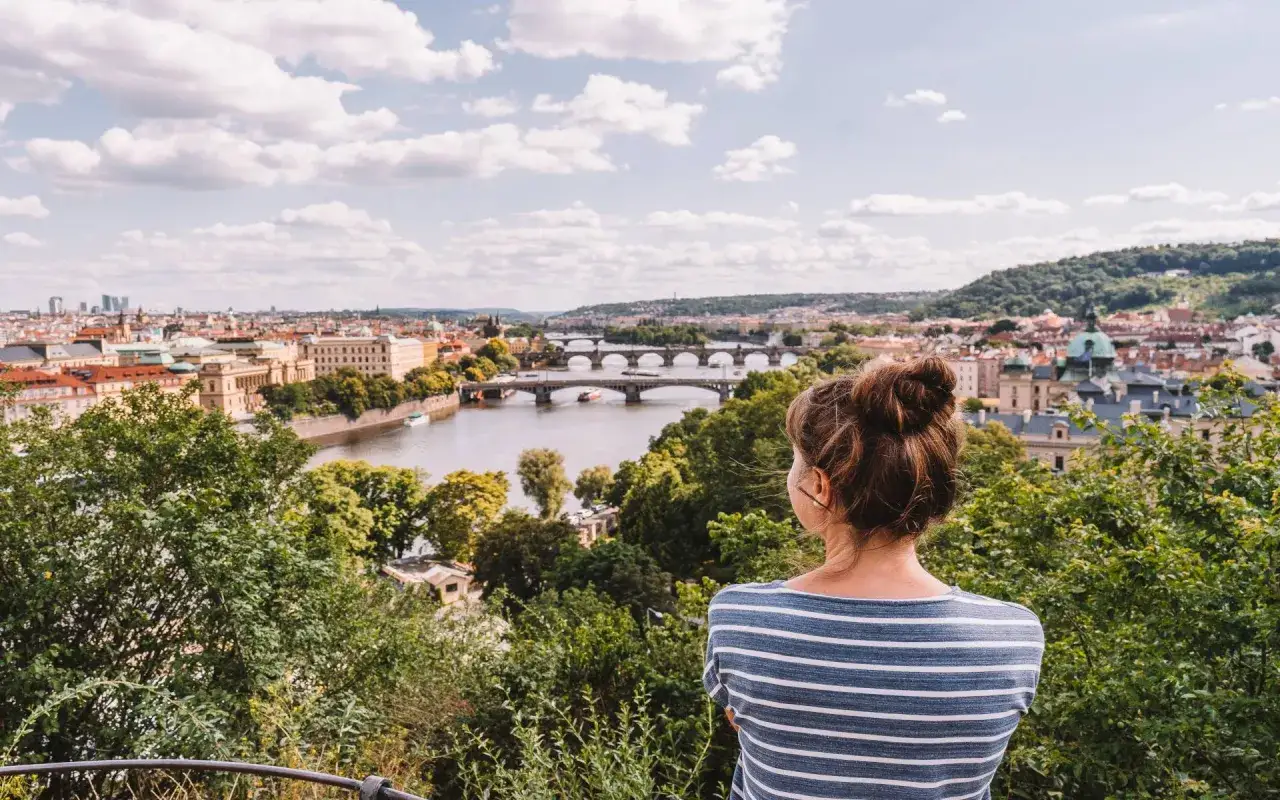 Frau blickt auf Prag, entdeckt versteckte Orte und genießt die Aussicht. Ein perfekter Ort für Prag Geheimtipps.