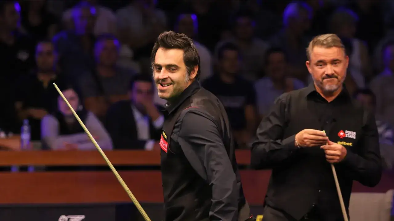 Ronnie O'Sullivan i Stephen Hendry, dwaj najlepsi snookerzyści wszechczasów, na tle publiczności.
