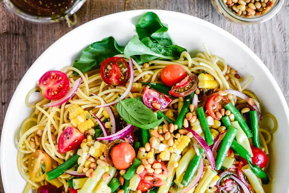 Bunter Spaghetti-Salat mit Tomaten, Mais, grünen Bohnen und Pinienkernen – perfekt als leichter Spaghetti Salat zum Grillen.