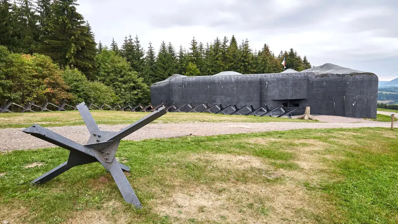 Betonowy bunkier i jeż przeciwczołgowe na tle lasu. Jedna z atrakcji Trutnova, która przenosi w czasy historii.