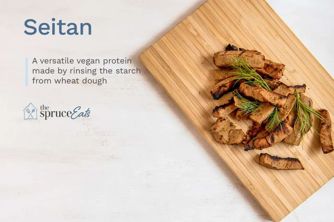 Seitan, prote&iacute;na vegana vers&aacute;til hecha de masa de trigo. Trozos dorados y a la parrilla con eneldo fresco sobre tabla de madera.