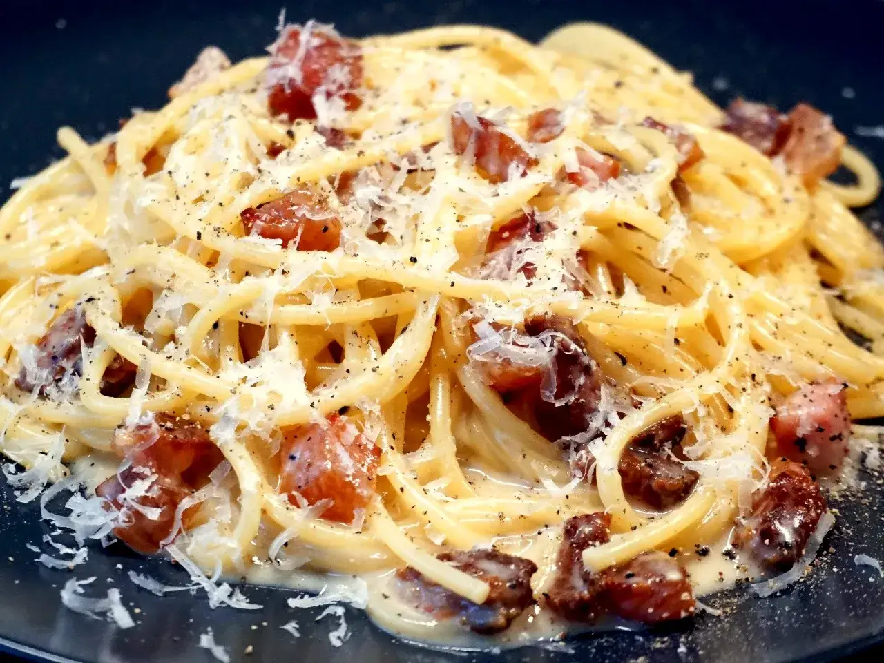 En krämig portion pasta carbonara med krispigt sidfläsk och rikligt med parmesanost.