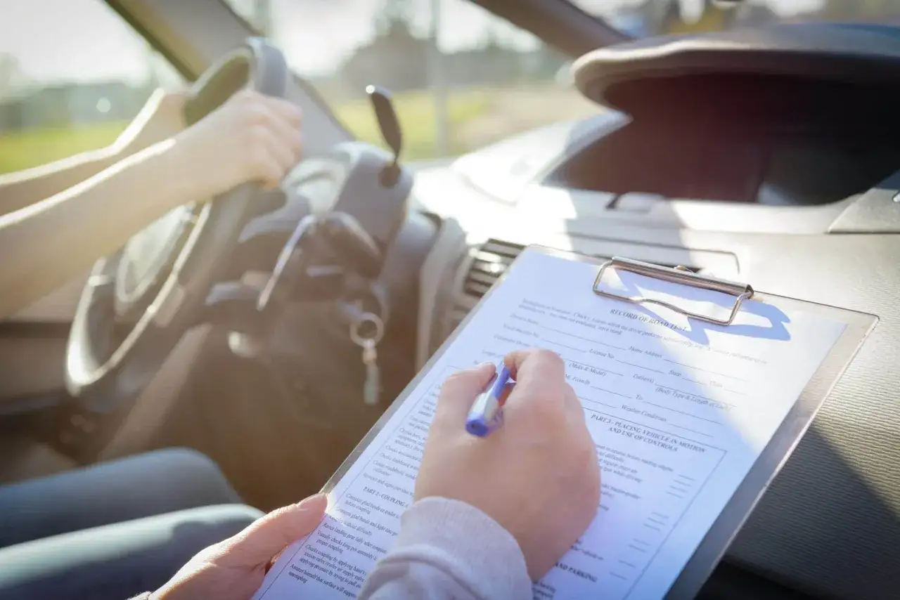 Persona llenando un formulario de examen de manejo, un paso clave para saber como sacar el carnet de conducir.