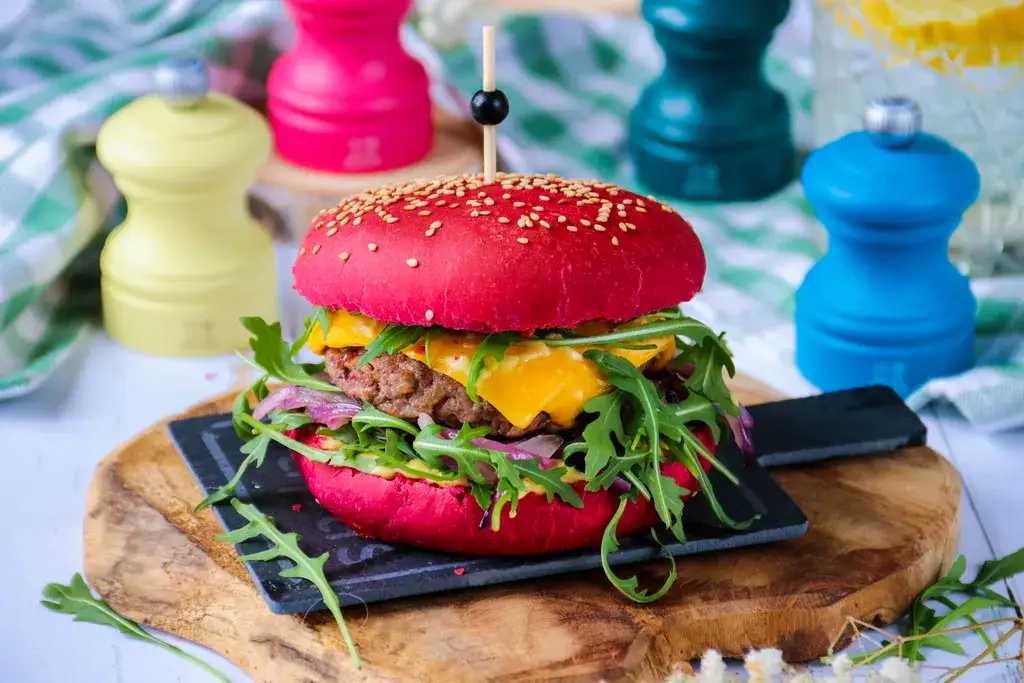 Pains &agrave; burger color&eacute;s naturellement noir et rose sur une grille