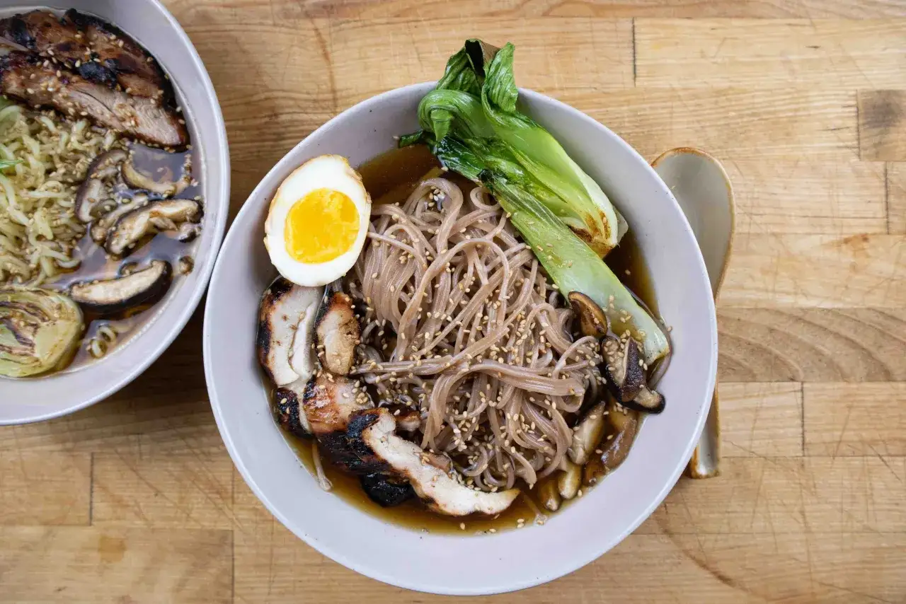 Dwie miski pysznego ramen: jeden z grillowanym kurczakiem, grzybami i jajkiem, drugi z wieprzowiną i warzywami. Idealne danie, by dowiedzieć się, co to ramen.
