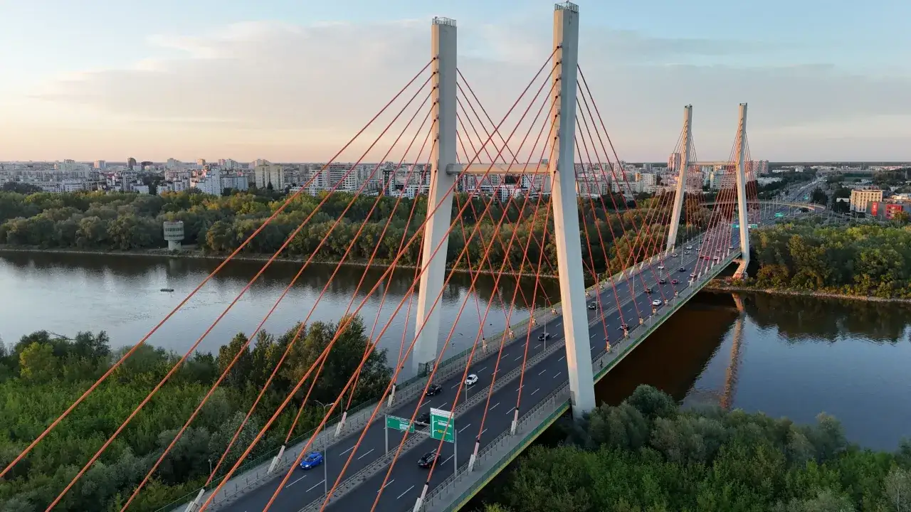 Most Siekierkowski w Warszawie o zachodzie słońca, z widokiem na Wisłę i panoramę miasta.
