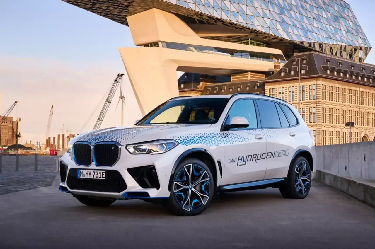 BMW iX5 Hydrogen, ein Vorreiter unter den BMW Elektro Modellen, mit futuristischer Architektur im Hintergrund.