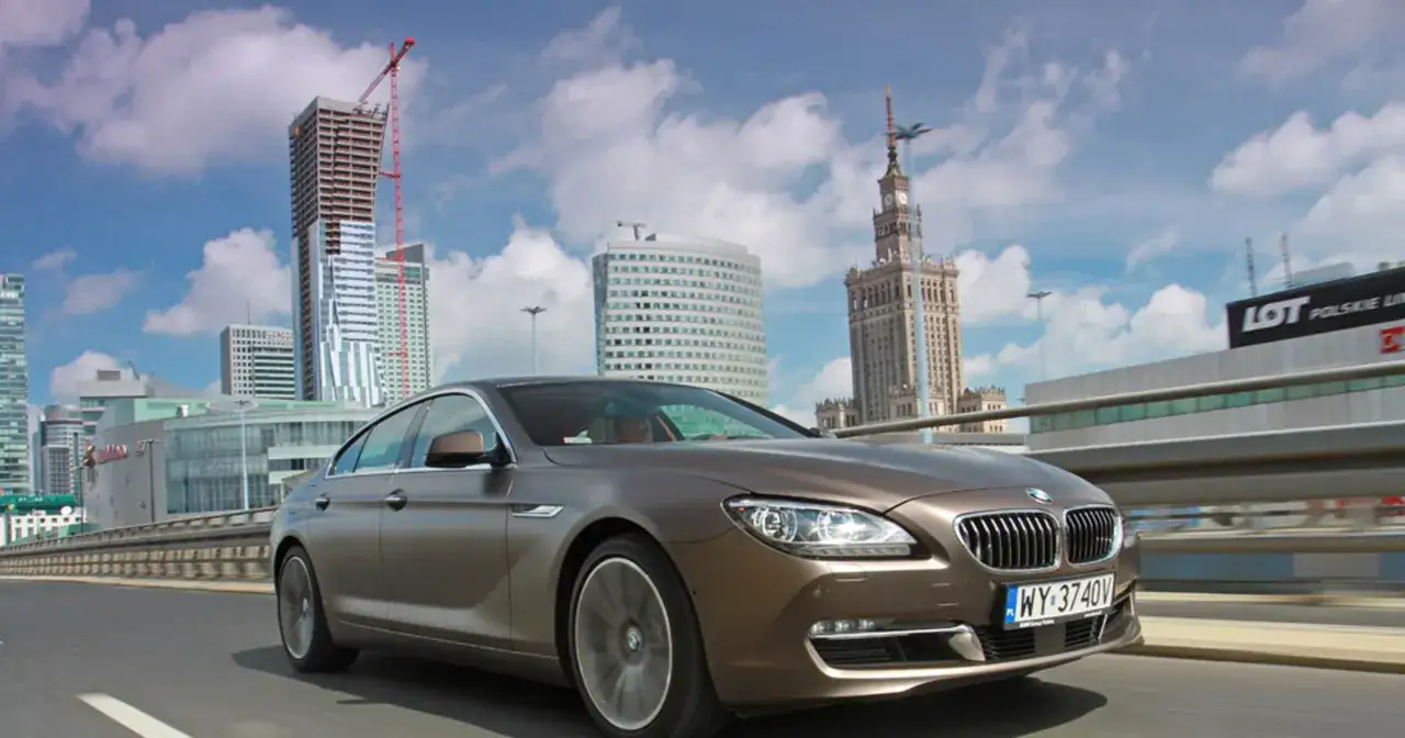 Eleganckie bmw seria 6 jedzie przez miasto z nowoczesnymi wieżowcami w tle.